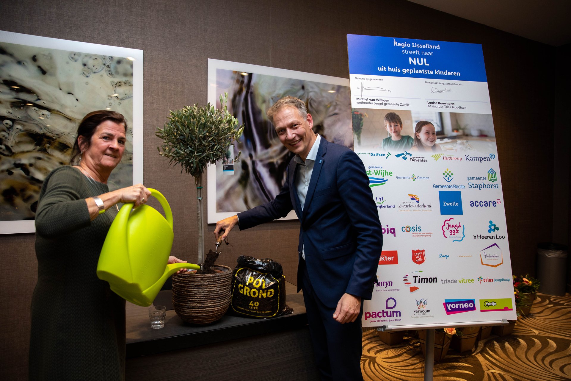 Foto: Louise Rouwhorst en Michiel van Willigen planten en begieten een boompje, symbool voor het opgroeien van een kind.